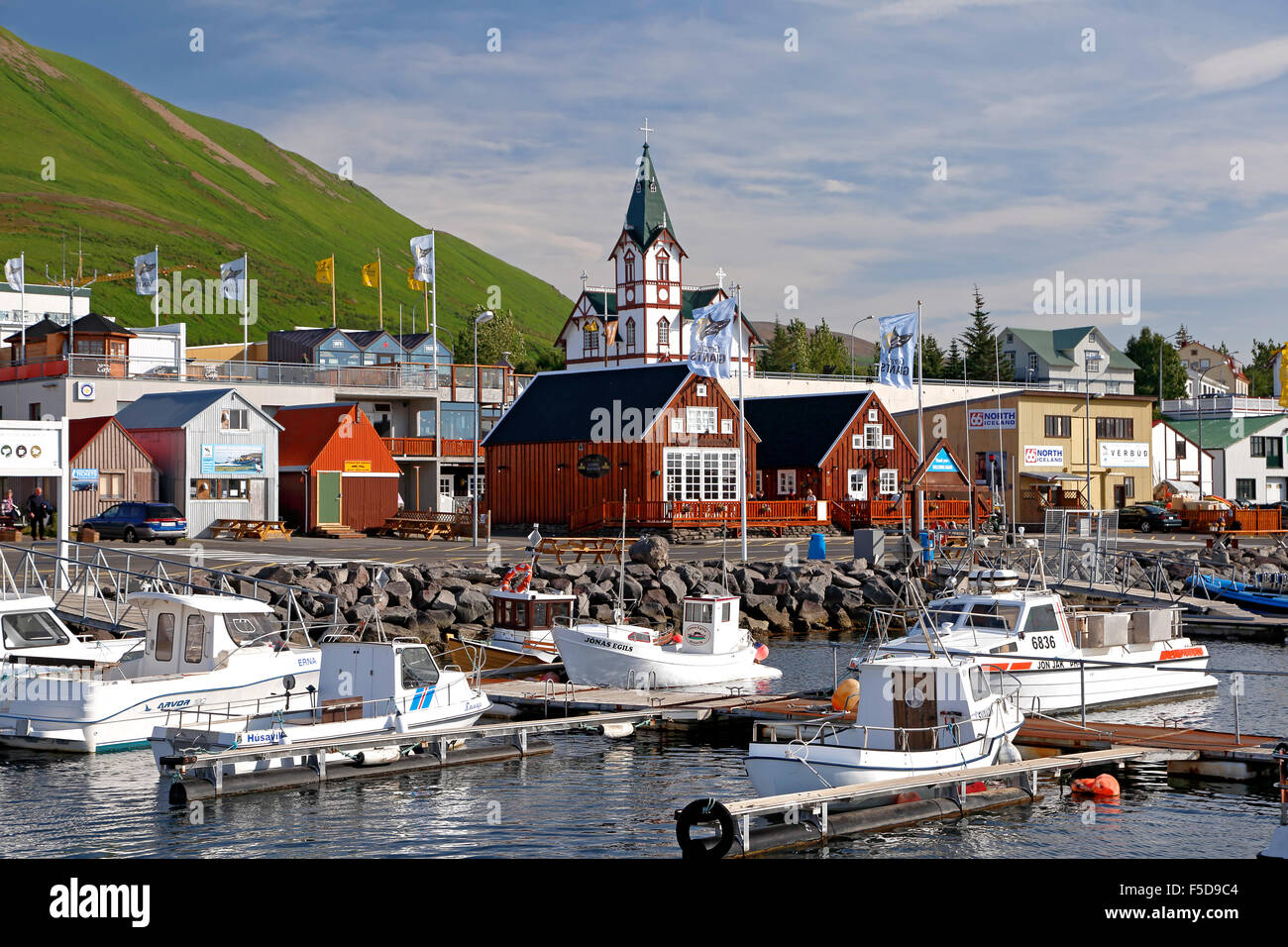 Boats, colorful buildings and church, Husavik Harbor, Husavik, Iceland Stock Photo