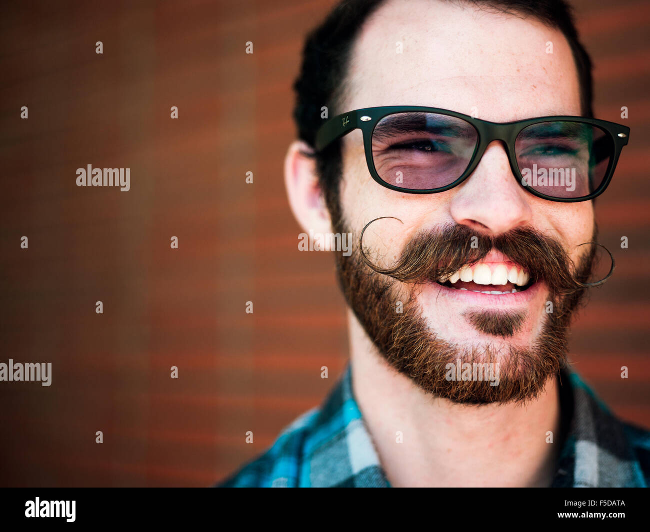 A young man with a twirled mustache smiling Stock Photo