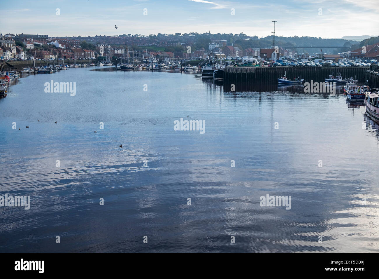 The entrance to Whitby harbour with the old town and church on top of the hill Stock Photo