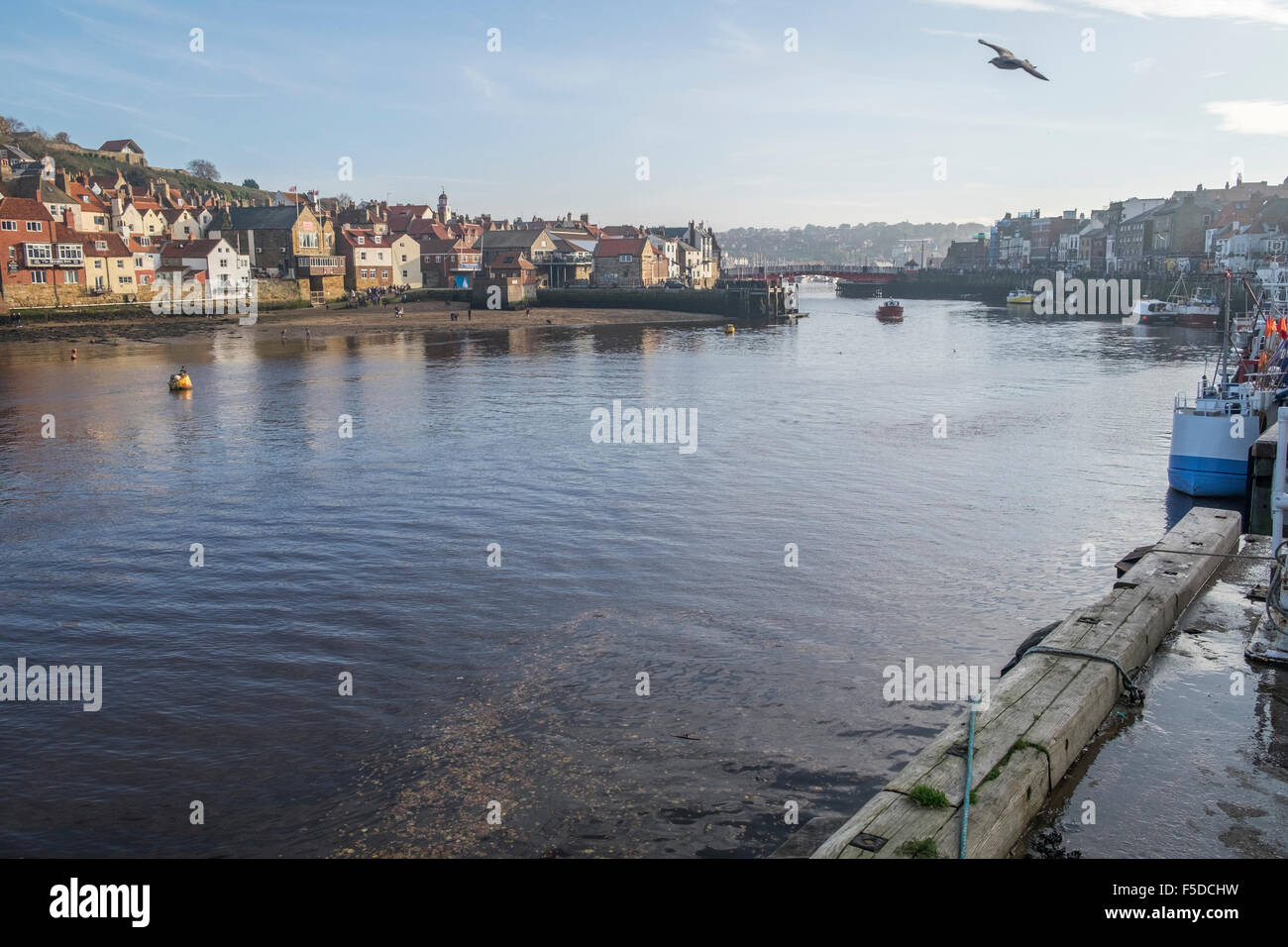 The entrance to Whitby harbour with the old town and church on top of the hill Stock Photo
