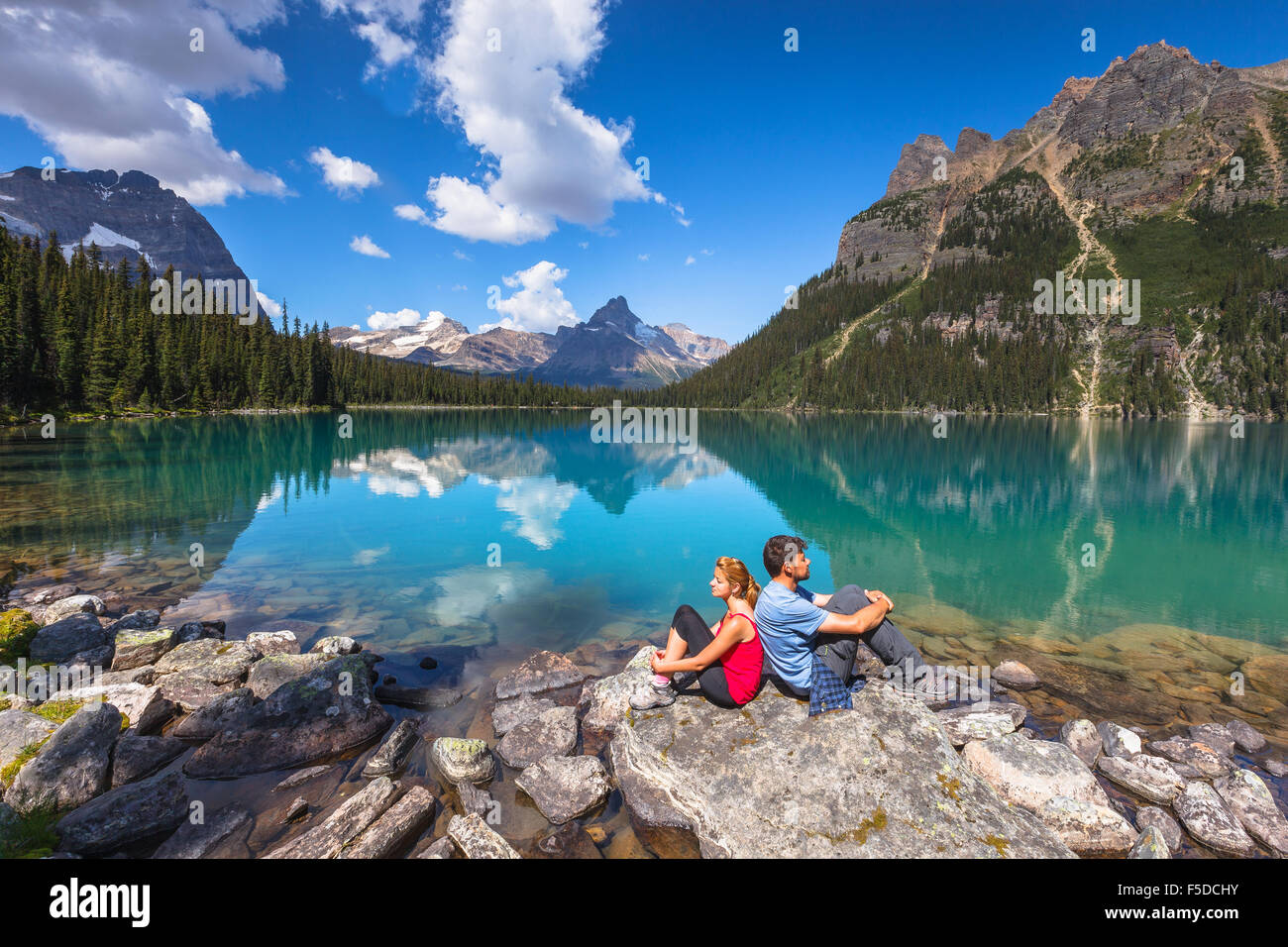 A young couple by beautiful Lake O'Hara in Yoho National Park, British Columbia, Canada, America Stock Photo -