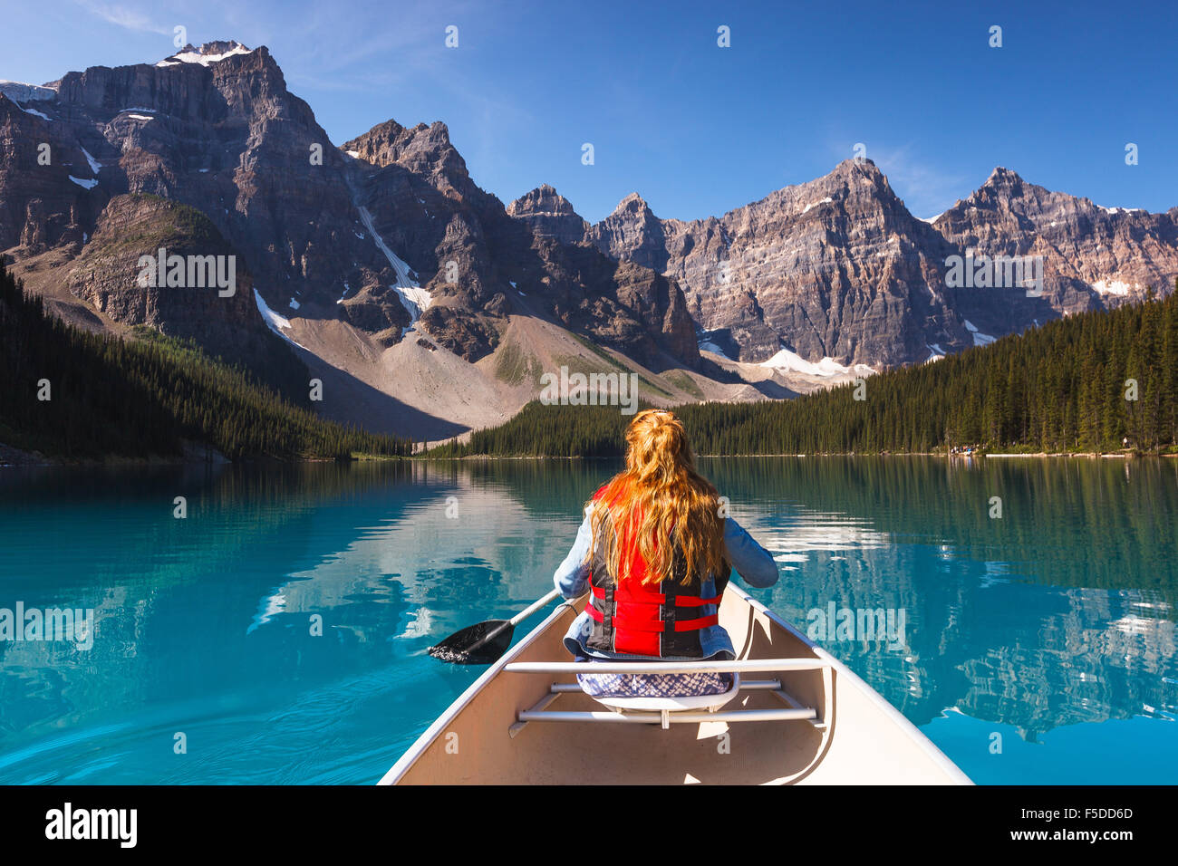 A young woman canoing at Moraine Lake, Banff National Park, Alberta, Canada, America (Canadian Rocky Mountains). Stock Photo