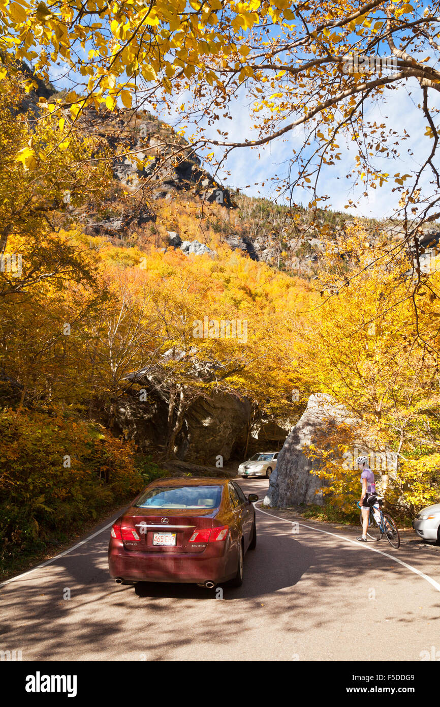 Cars and cyclists going through the narrow Smuggler's notch in autumn, Stowe, Vermont VT New England USA Stock Photo