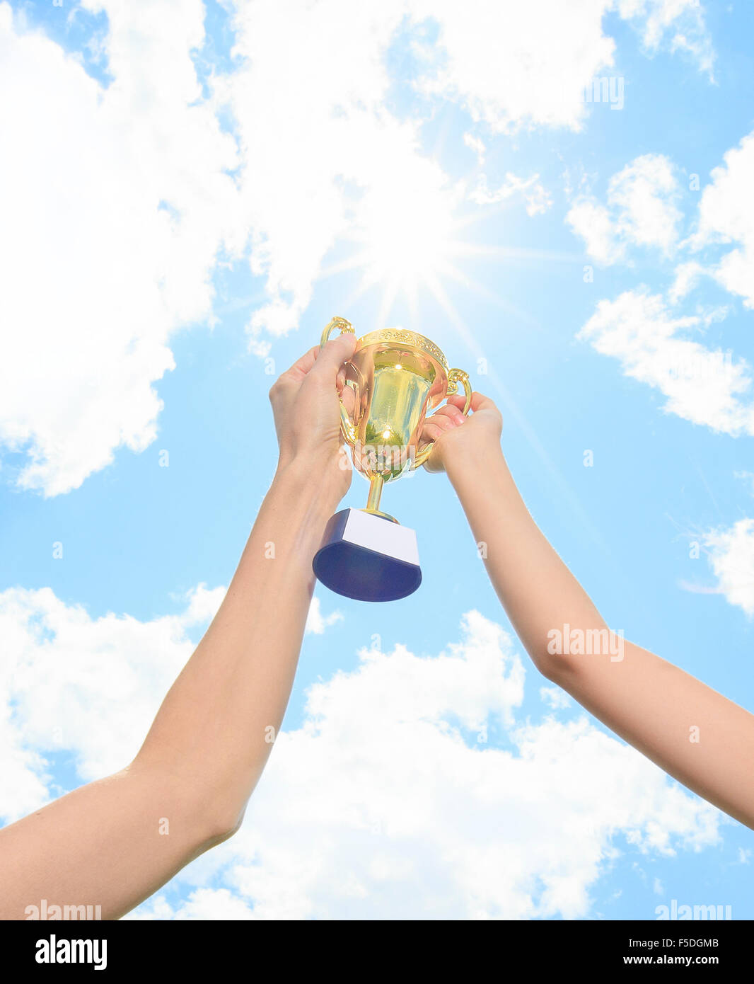 Happy mother and daughter holding a trophy high up Stock Photo