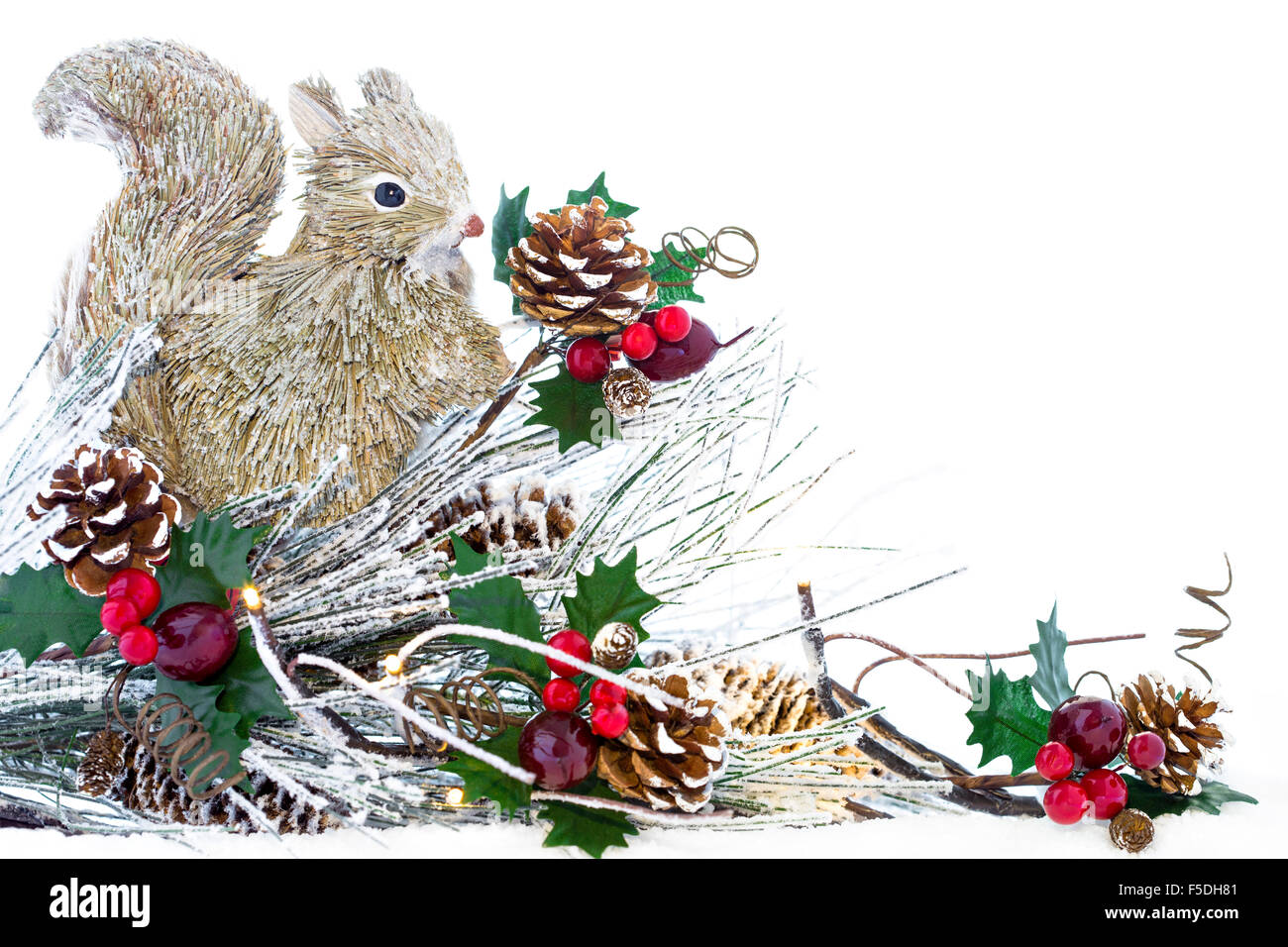 A Christmas decoration with wood squirrel, Christmas lights, pine cones