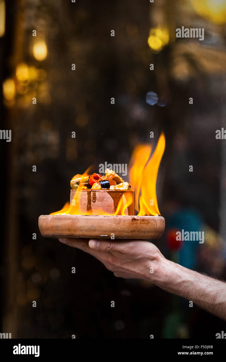 Man hand holding food plate on fire Stock Photo
