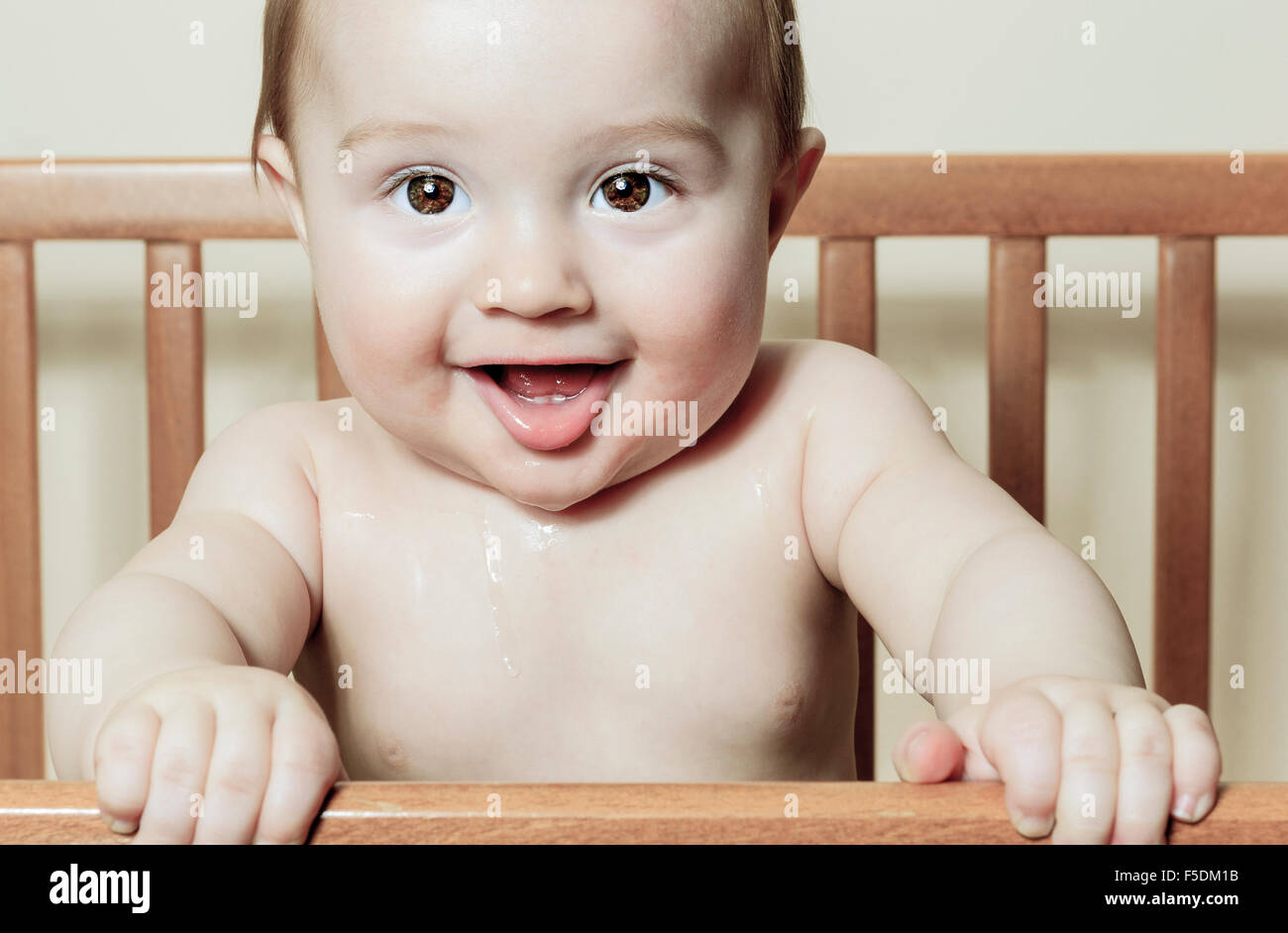 Funny Little Baby With Beautiful Standing In A Round White Crib