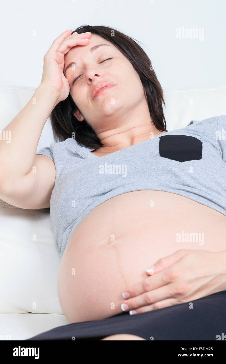 Struggling with morning sickness. Depressed pregnant woman holdi Stock Photo