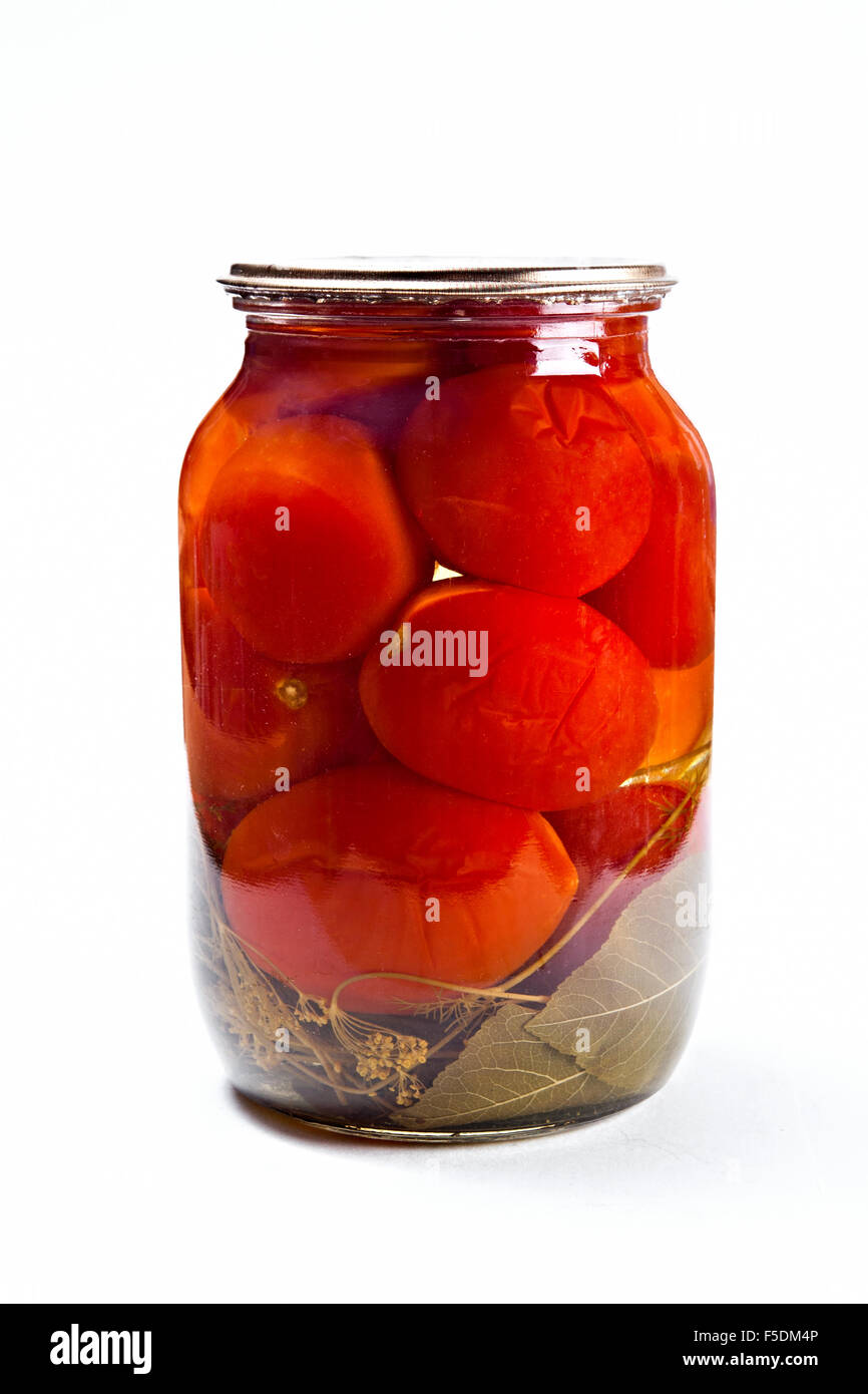 Tomatoes vegetables canned in glass jar isolated on white background