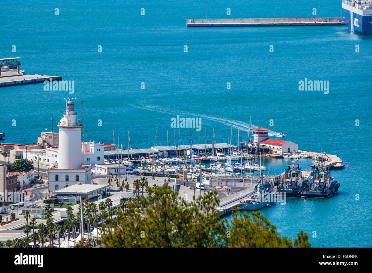 view of La Farola, the Malaga lighthouse with yacht harbour and Muelle uno, Wharf No. 1 at the Port of Malaga, Costa del Sol Stock Photo