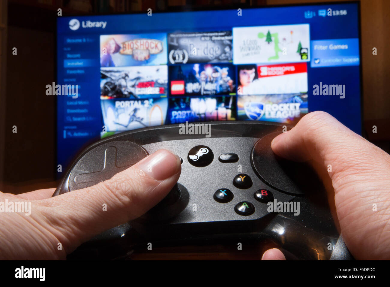 A Steam Controller being used to navigate a PC video game library on a TV  Stock Photo - Alamy