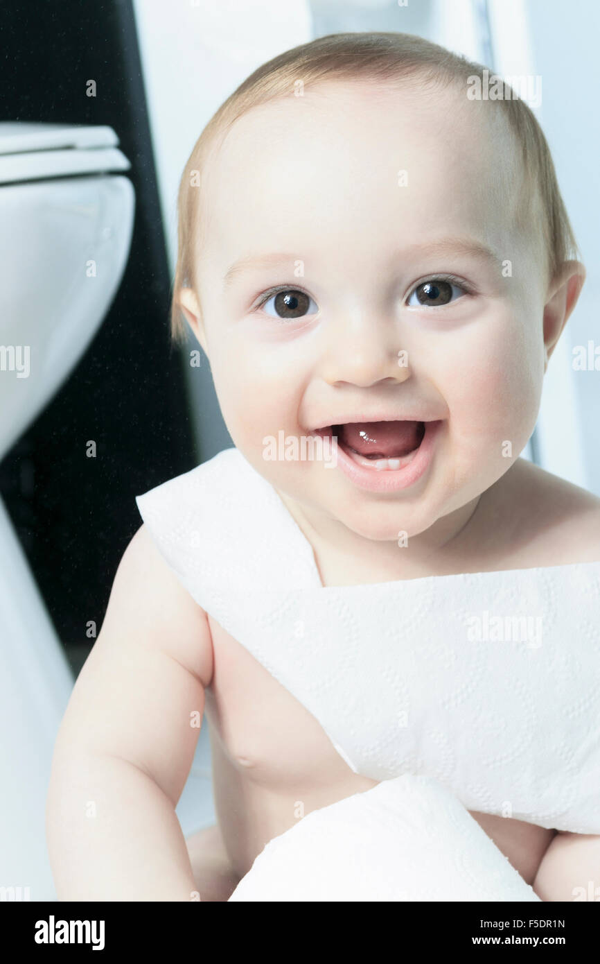 Toddler ripping up toilet paper in bathroom Stock Photo Alamy