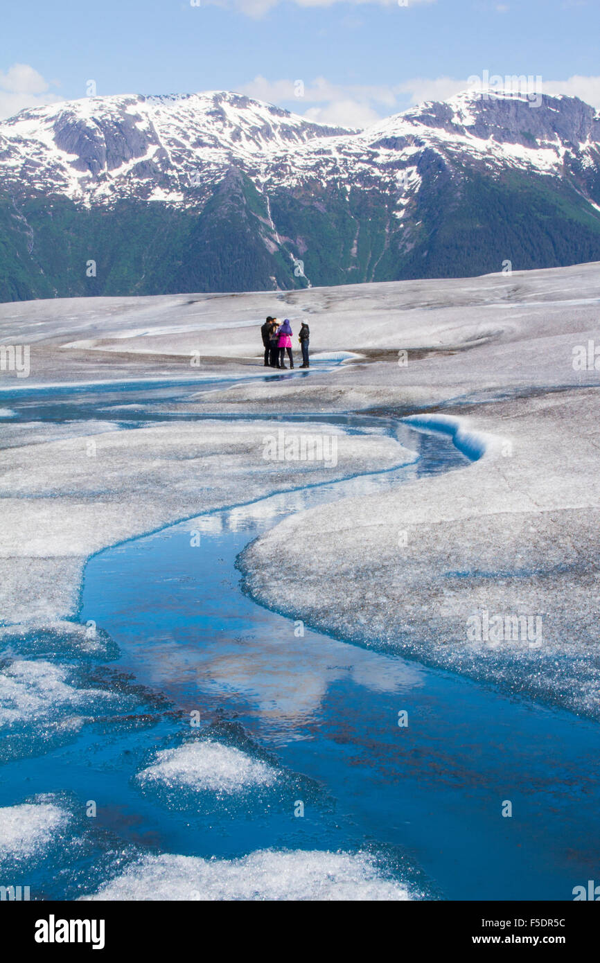 A helicopter flightseeing tour out of Juneau lands guests on Taku Glacier, part of the 1,500-sq. mi. Juneau Icefield, Juneau, AK Stock Photo
