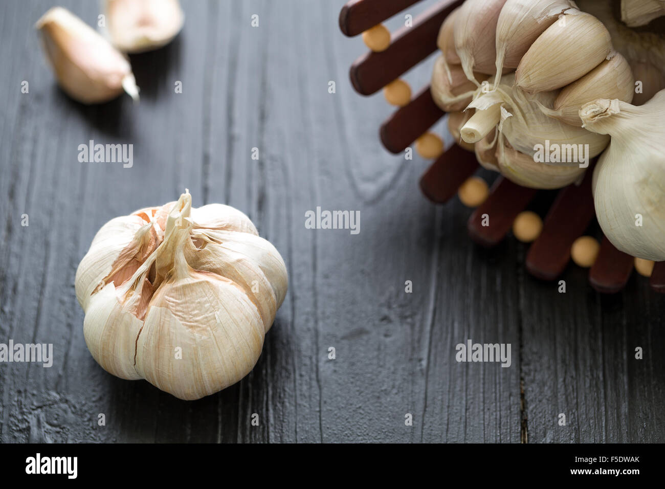 Raw garlic on black wooden table background Stock Photo - Alamy