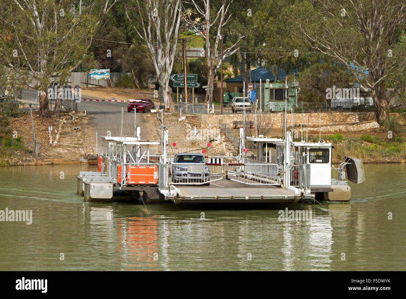 Vehicular ferry crossing Murray River with car on board & reflected in
