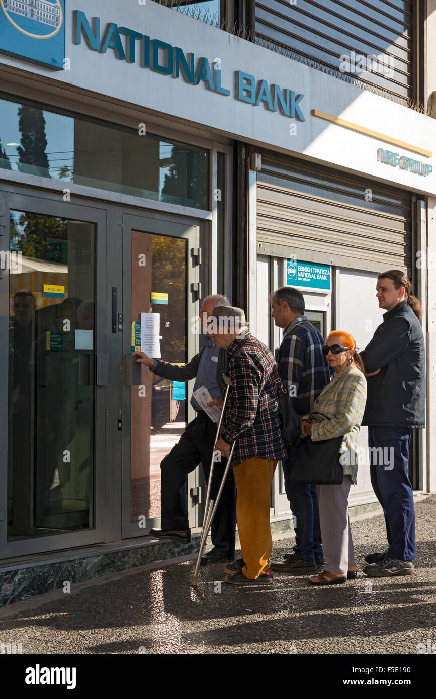 ATHENS, GREECE - OCTOBER 27, 2015: People queuing at the door of a bank Stock Photo