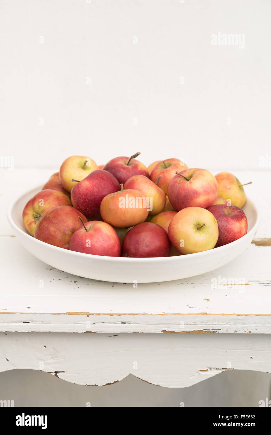 Small Danish apples in a big white bowl Stock Photo
