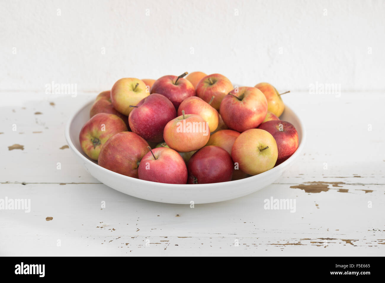 Small Danish apples in a big white bowl Stock Photo