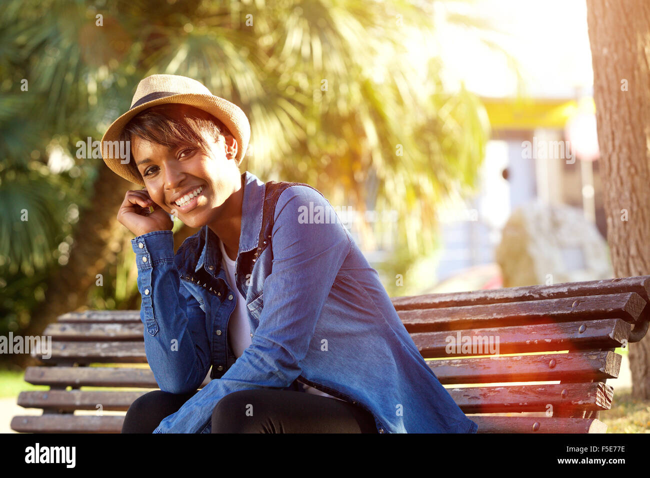 Portrait of a smiling young african american woman sitting outside ...