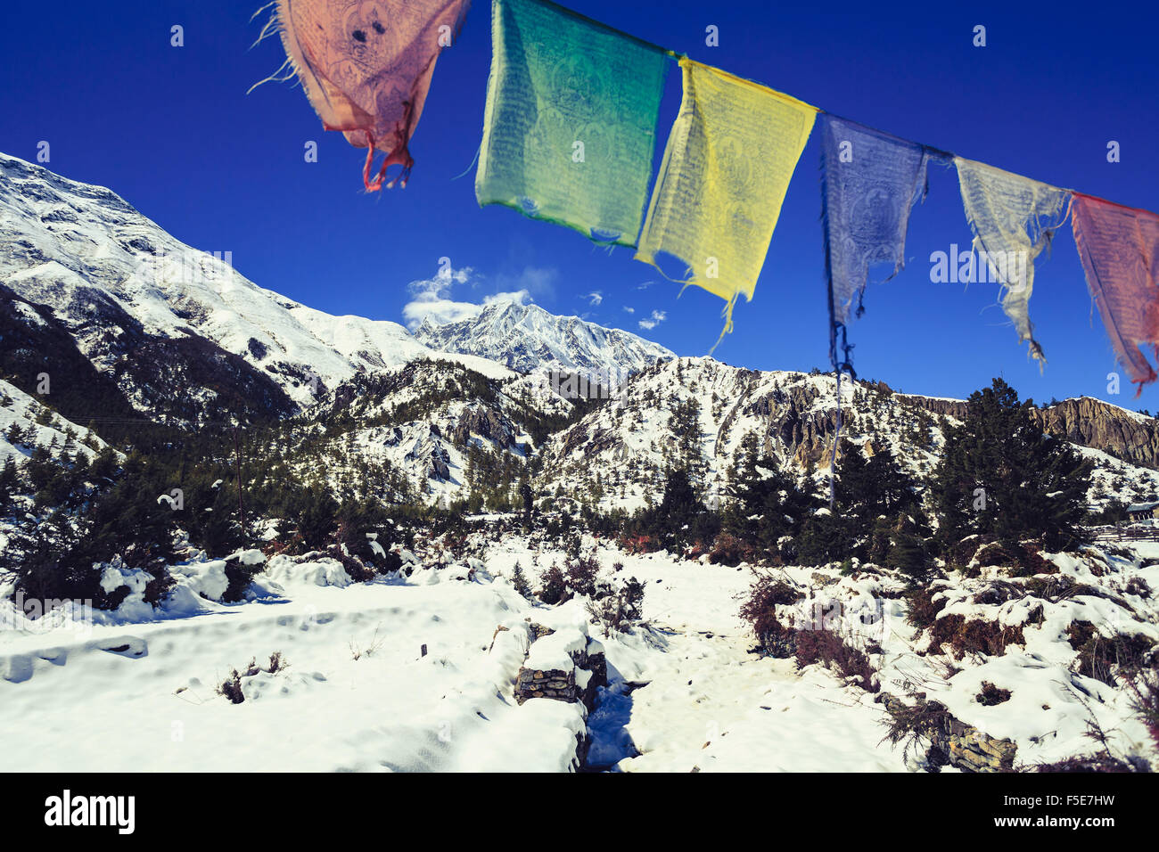 Mountain inspirational landscape in Himalayas, Annapurna range, Nepal. Prayers flag, Mountain ridge with ice and snow over clear Stock Photo