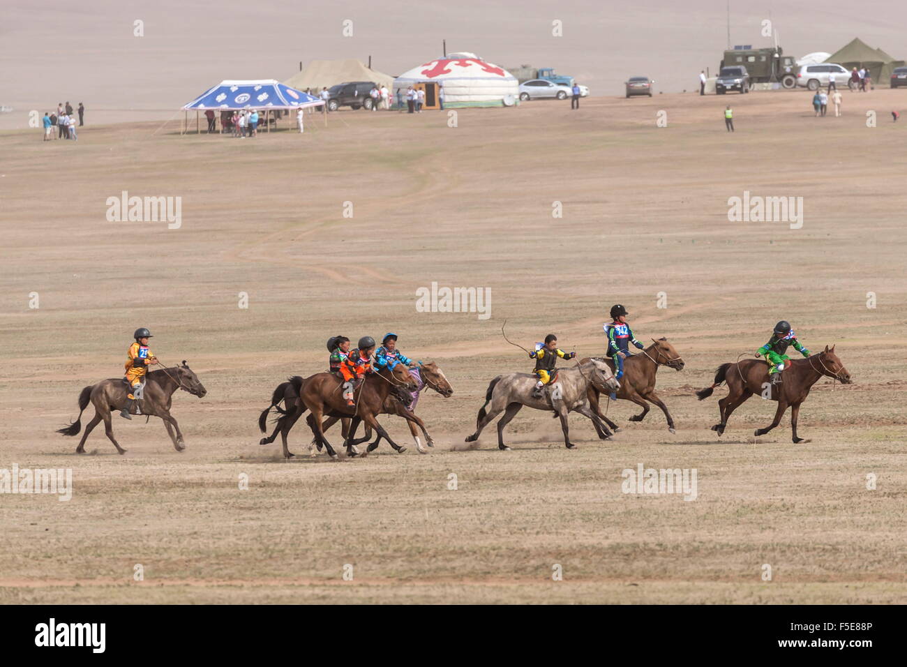 Child jockeys in a dash for the line, five-year old horse race, Naadam Festival, Hui Doloon Khutag, Ulaan Baatar, Mongolia, Asia Stock Photo