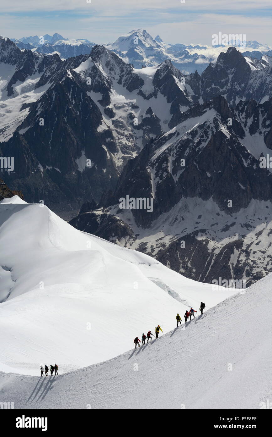 Mountaineers and climbers hiking on a snowy ridge, Aiguille du Midi, Mont Blanc Massif, Chamonix, Haute Savoie, French Alps Stock Photo