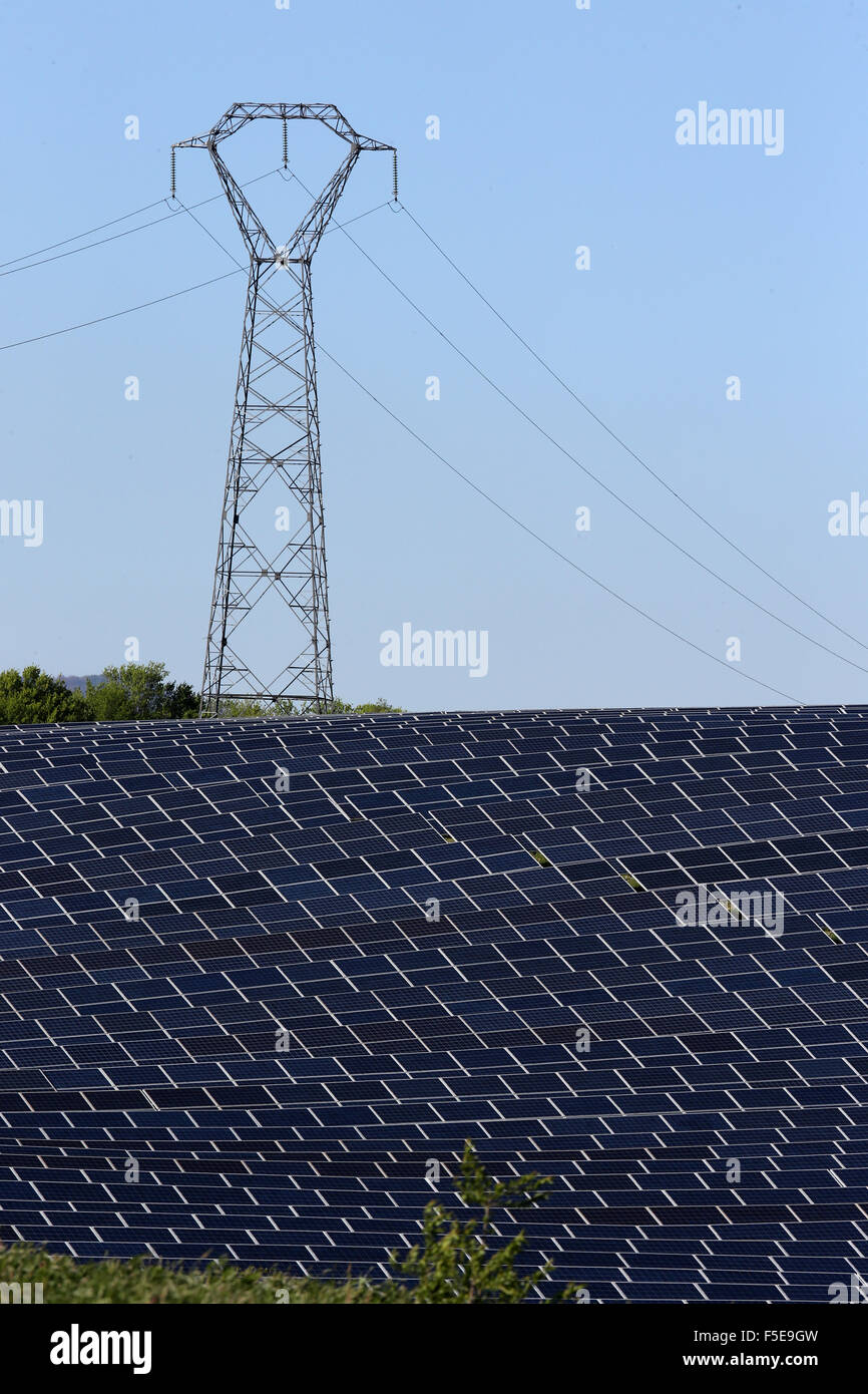 Solar farm, Photovoltaic power plant and pylon, Alpes-de-Haute-Provence, France, Europe Stock Photo
