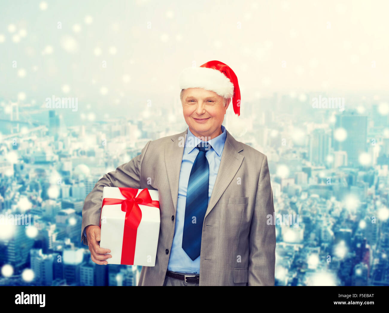 smiling man in suit and santa helper hat with gift Stock Photo - Alamy