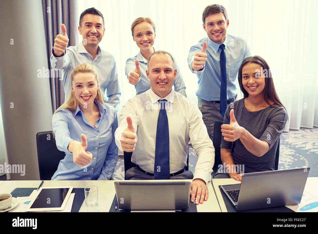 business people showing thumbs up in office Stock Photo - Alamy
