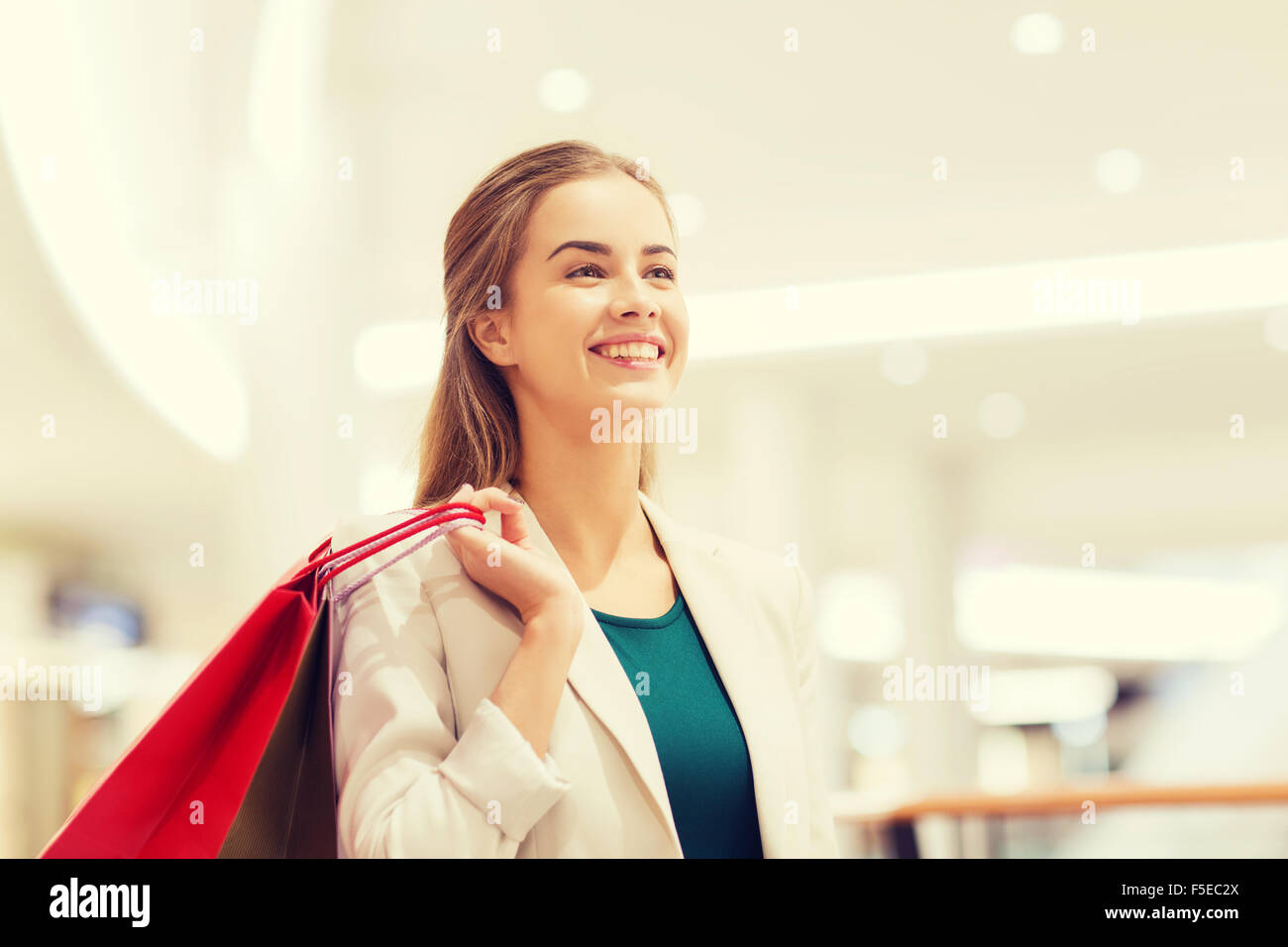 happy young woman with shopping bags in mall Stock Photo - Alamy