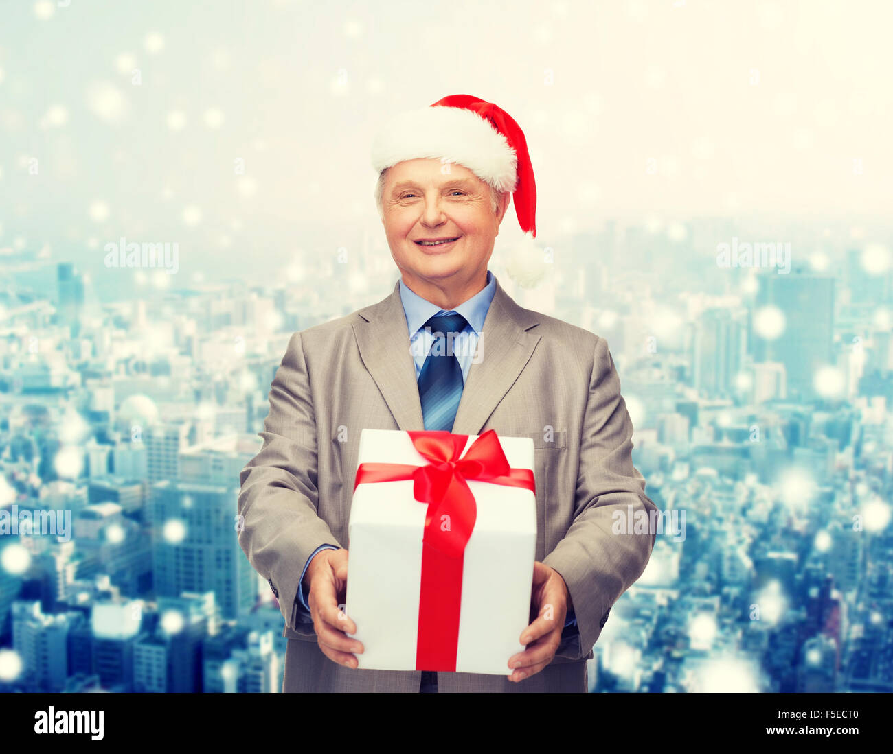 smiling man in suit and santa helper hat with gift Stock Photo - Alamy