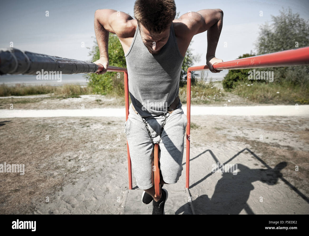 young man exercising on parallel bars outdoors Stock Photo - Alamy
