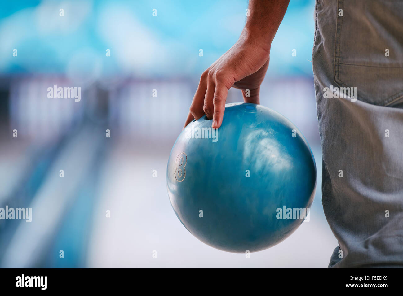 Young man in jeans holding bowling ball Stock Photo Alamy
