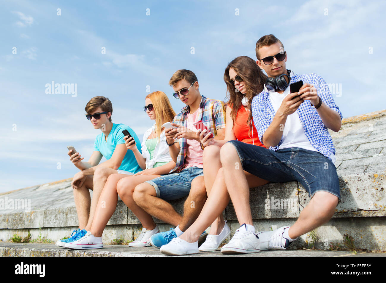 group of friends with smartphone outdoors Stock Photo