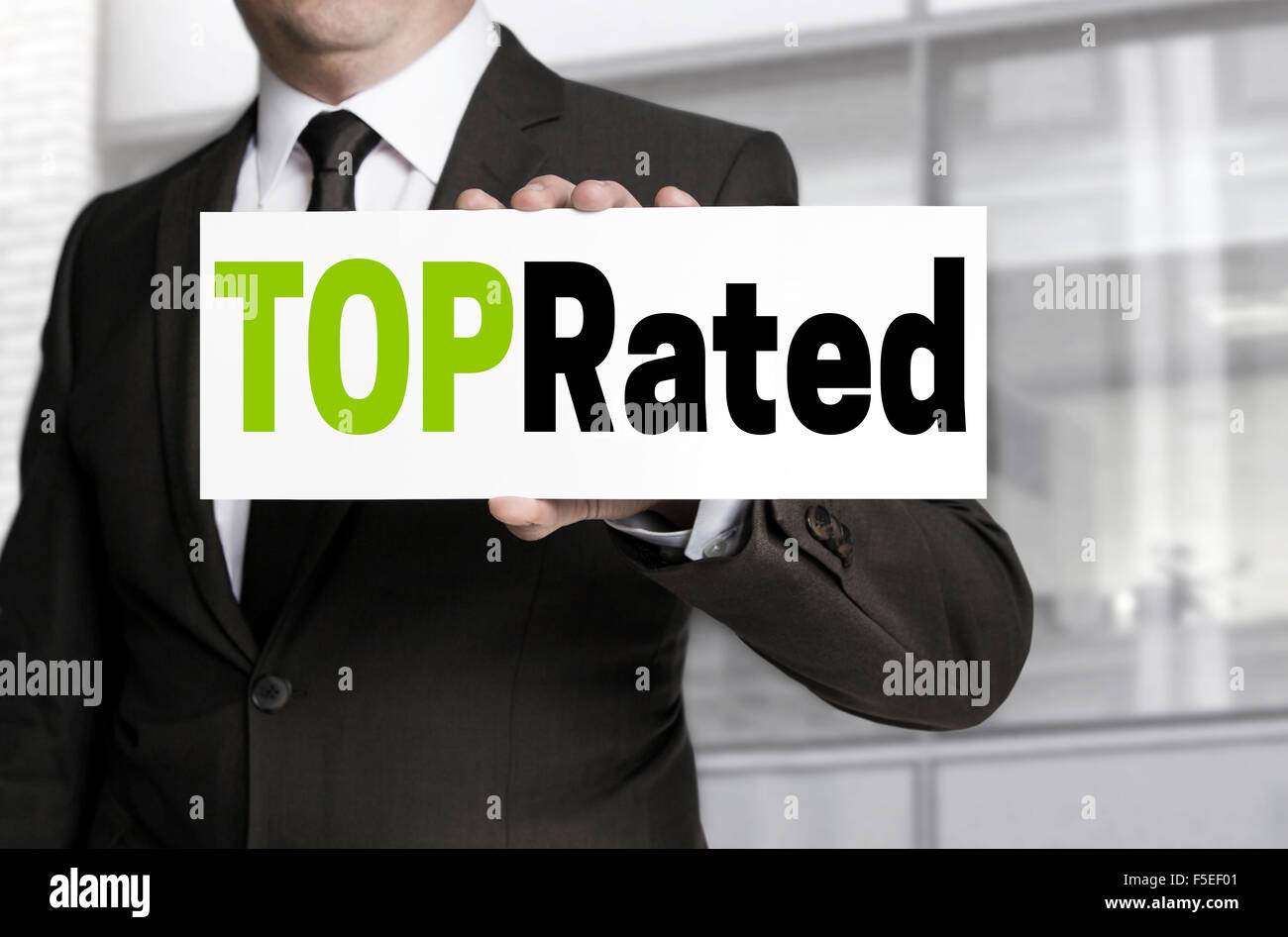 Top Rated sign is held by businessman concept. Stock Photo