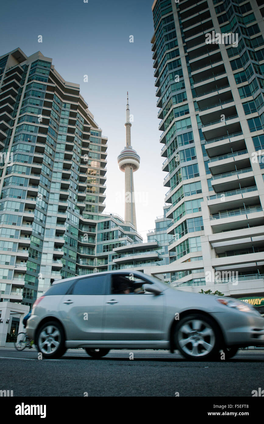 Car driving past skyscrapers with cn tower in the background hires