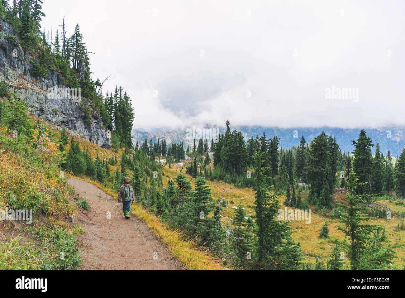 Rear view of a Boy hiking along mountain path Stock Photo