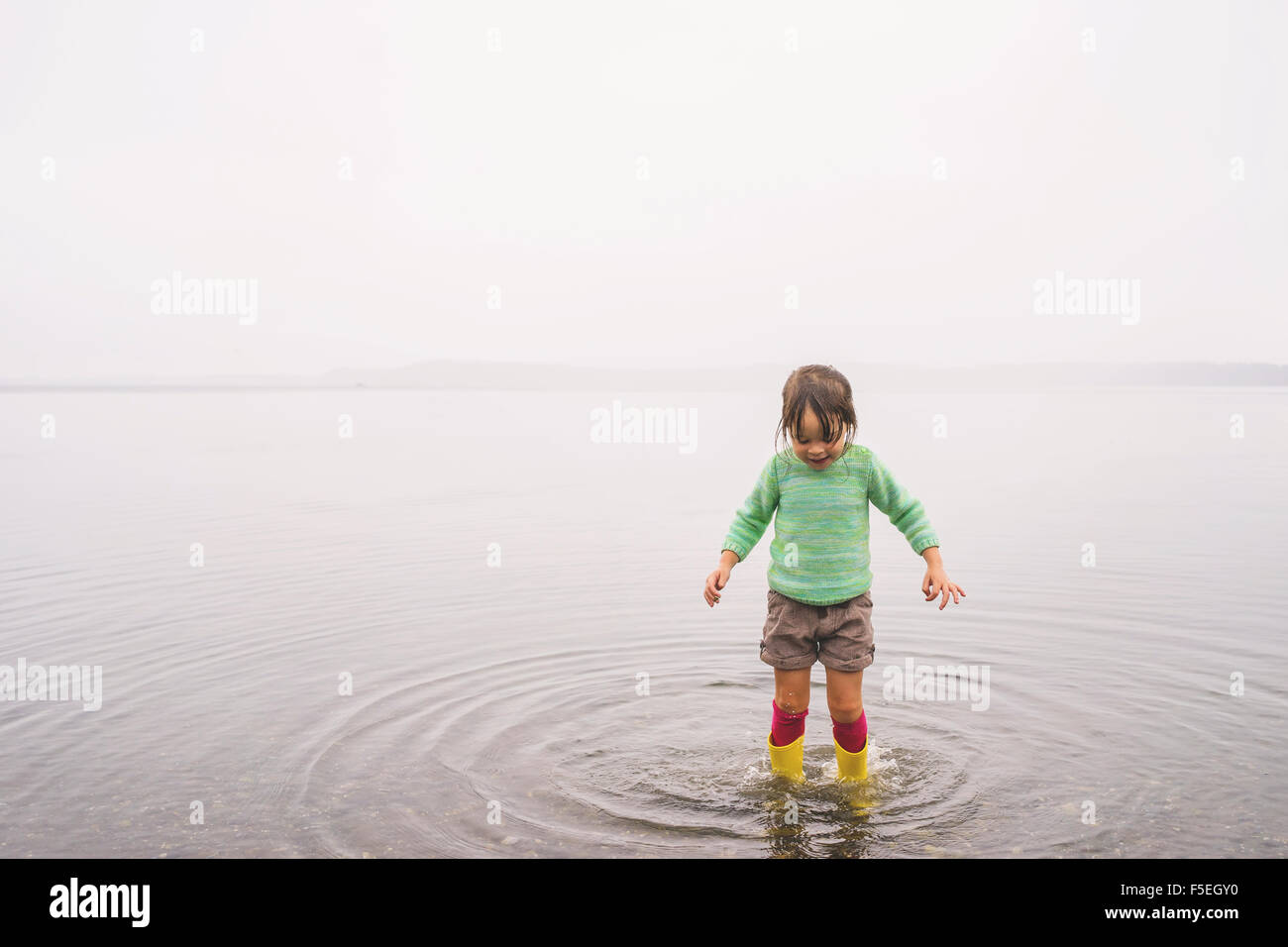 Girl standing in shallow water, making ripples Stock Photo Alamy