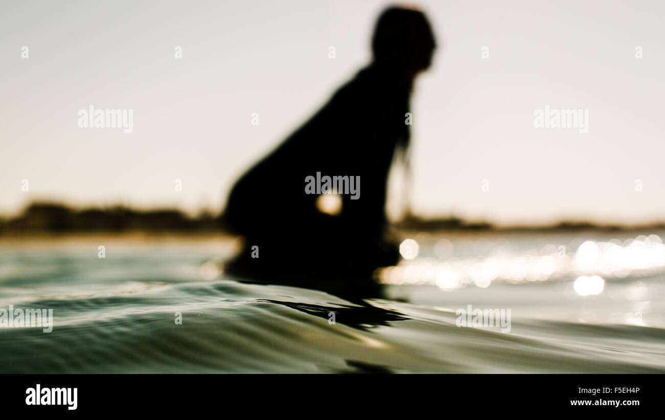 Silhouette of a women sitting on surfboard, California, USA Stock Photo
