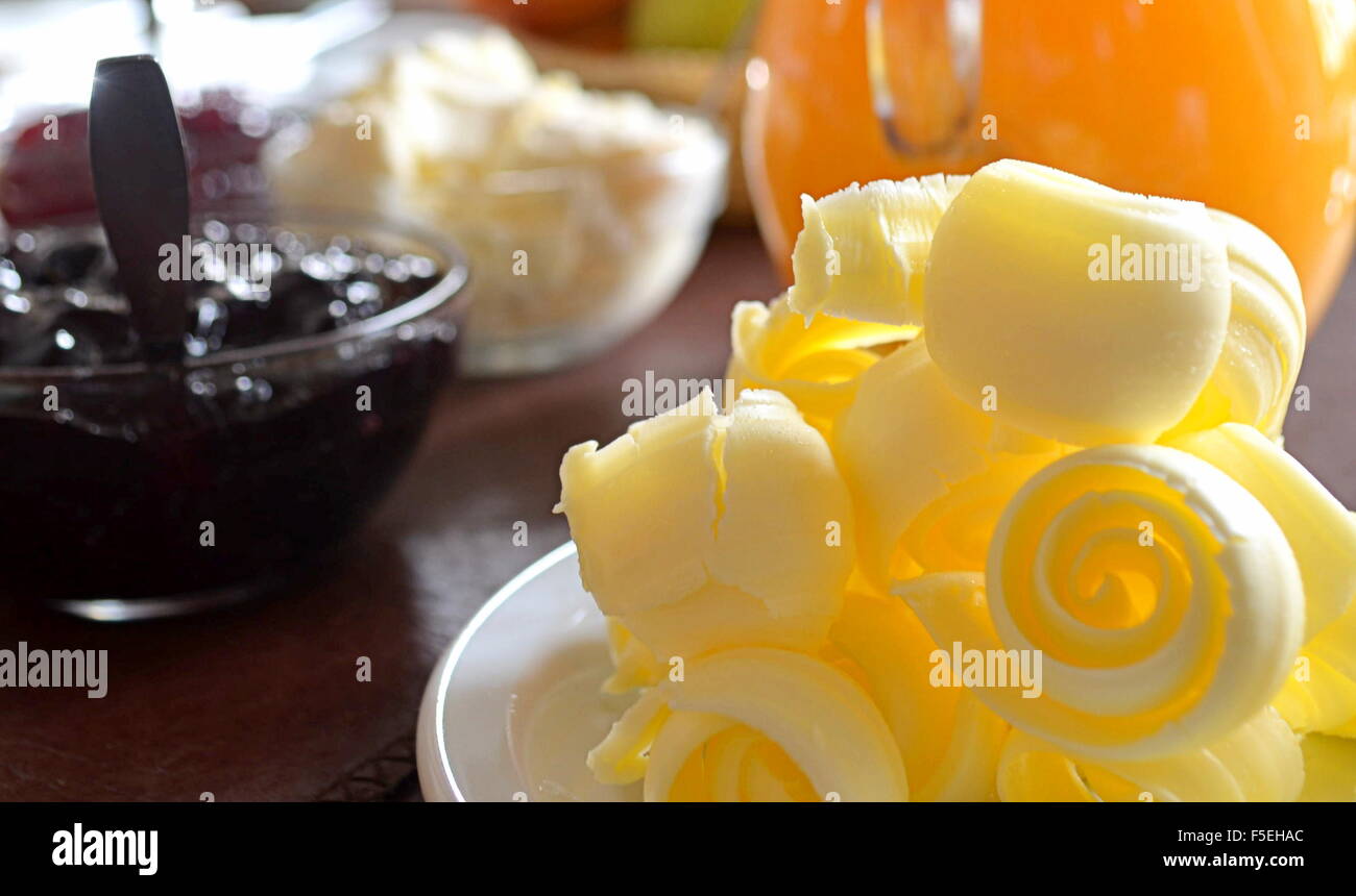 Close-up of butter curls, jam and juice Stock Photo