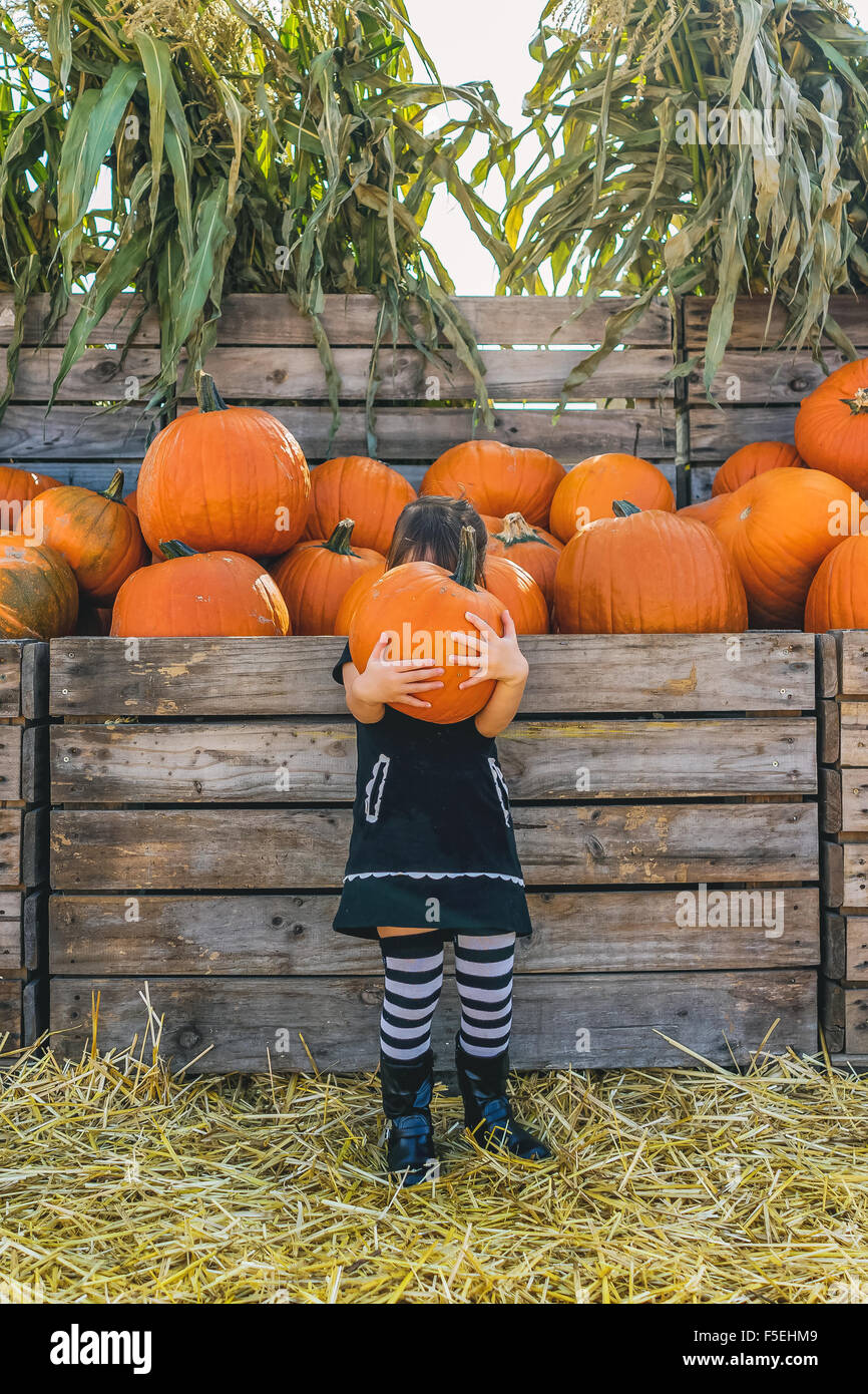 Girl holding large pumpkin at pumpkin farm Stock Photo
