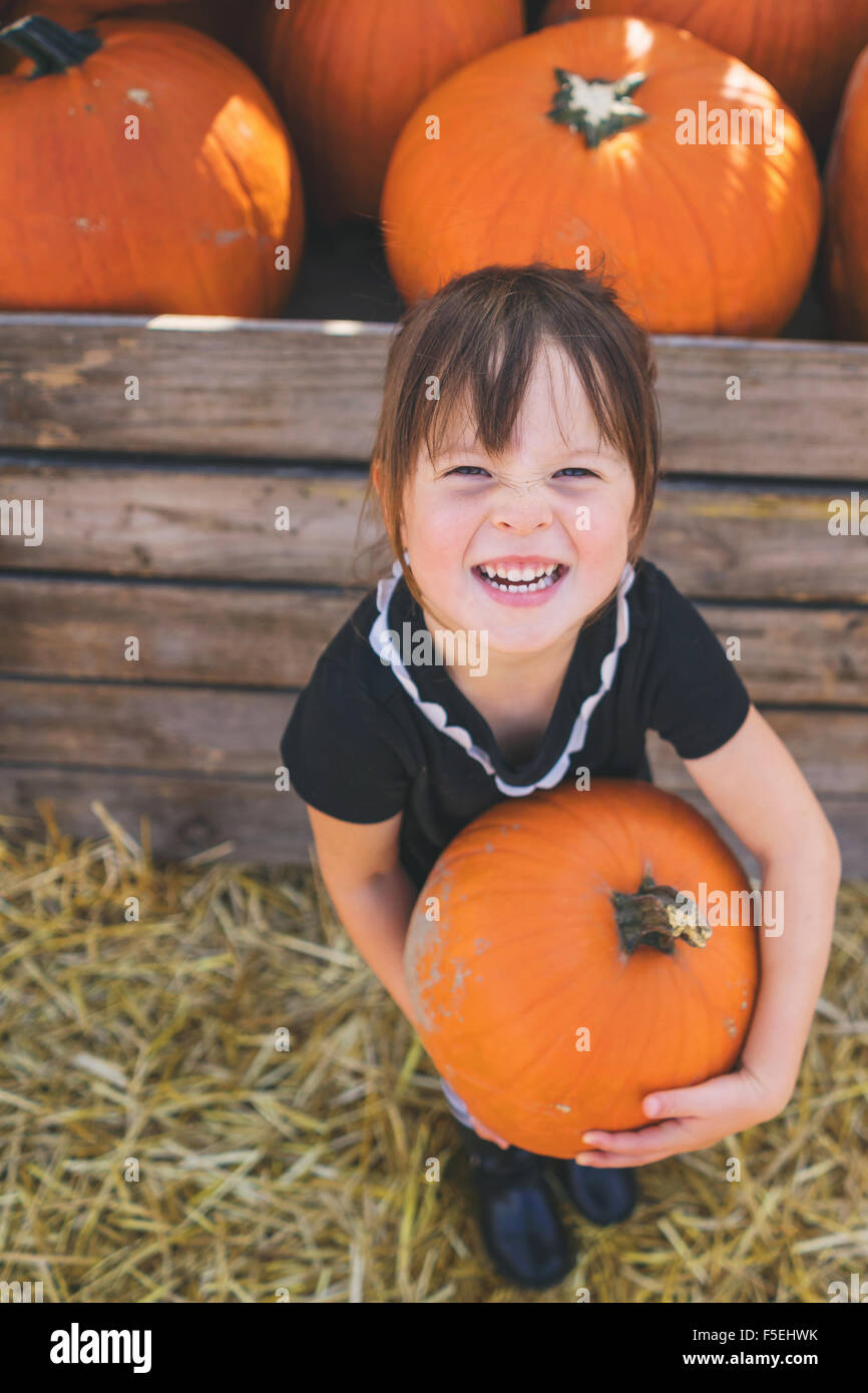 Smiling girl holding a giant pumpkin Stock Photo
