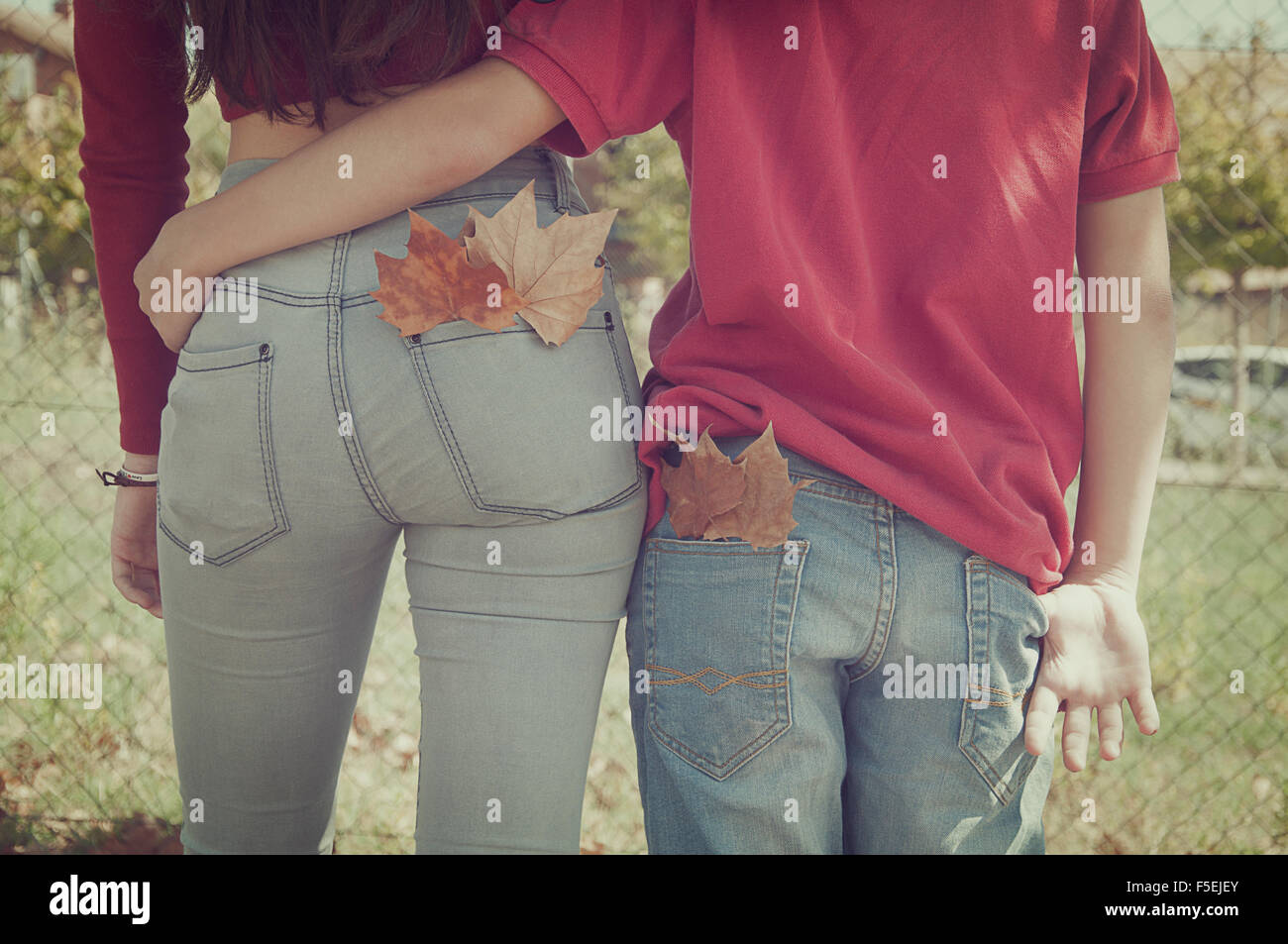 Rear view of a couple walking with their arms around each other Stock Photo