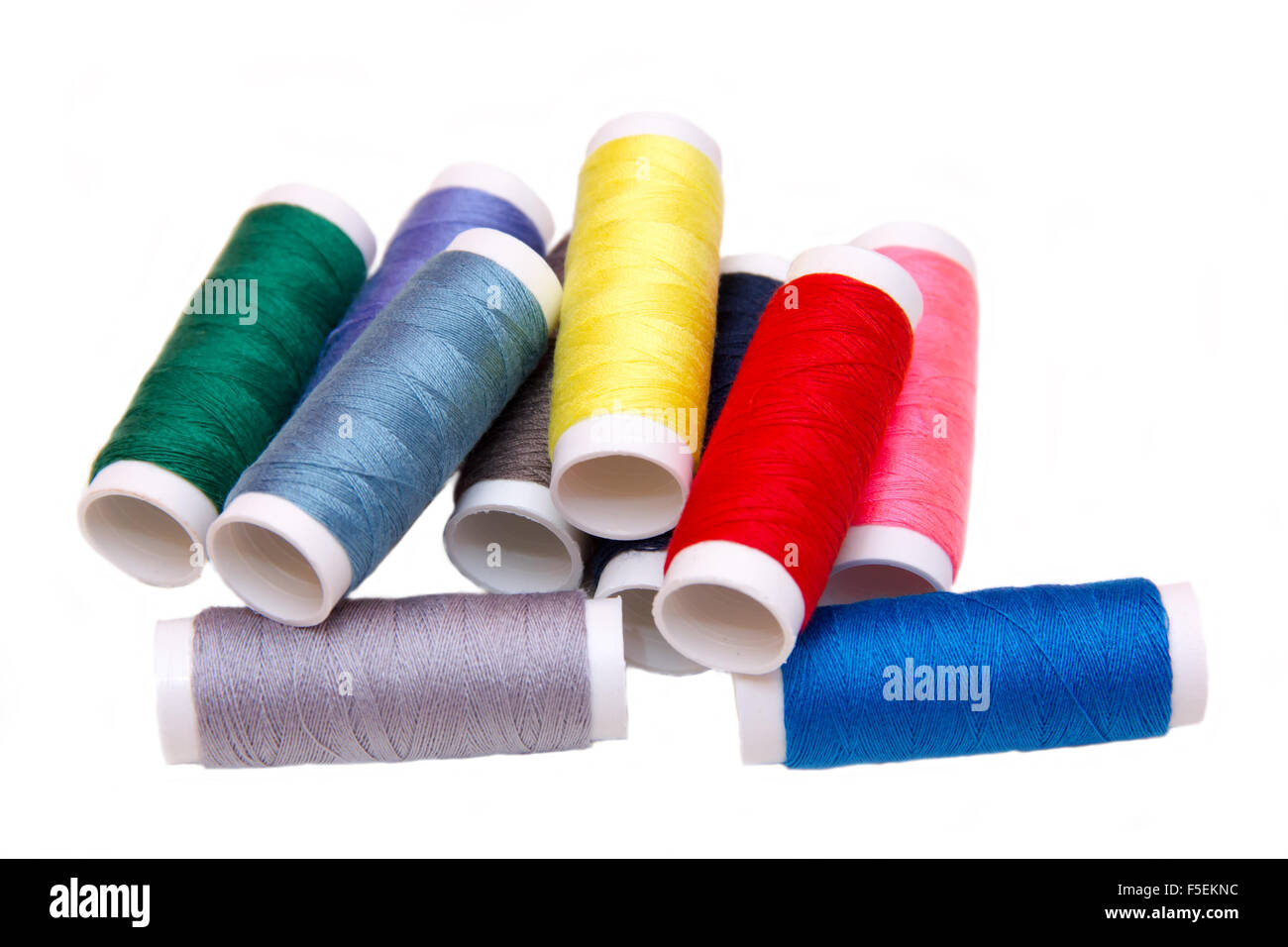 Sewing thread in different colors on white background Stock Photo - Alamy