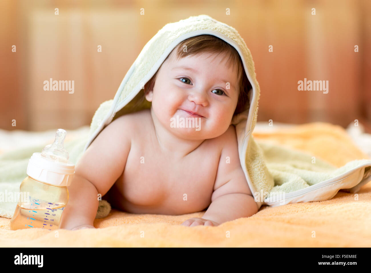 Adorable baby child under a hooded towel after bathing Stock Photo
