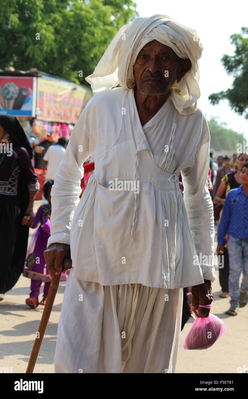 Old man in white clothes and turban, holding stick Stock Photo - Alamy