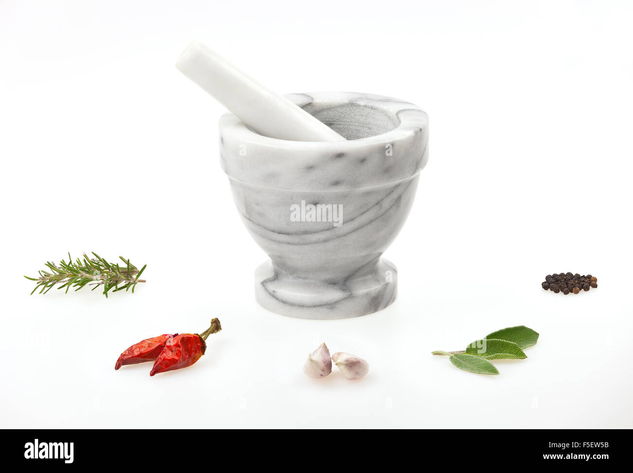 A traditional marble mortar and pestle with various herbs and spice isolated on white background Stock Photo