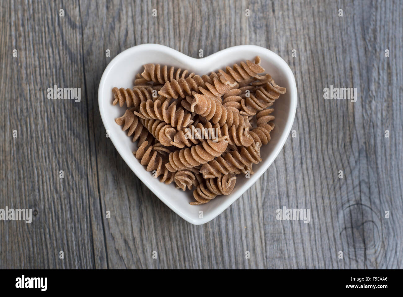 Wholegrain, spelt fusilli pasta in a heart shaped dish Stock Photo