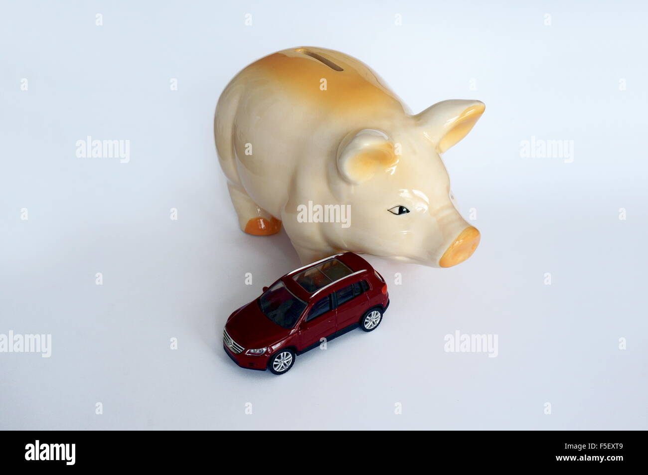 ILLUSTRATION - A Volkswagen car model 'VW Tiguan' next to a piggy bank . The photo was taken on 16 October 2015. Photo: S. Steinach - NO WIRE SERVICE - Stock Photo