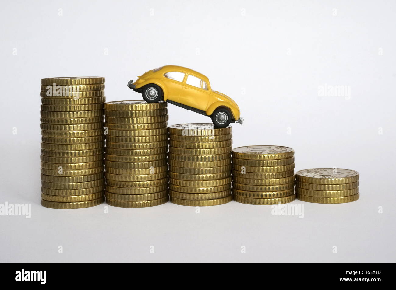 ILLUSTRATION - A Volkswagen Beetle model on decreasing money piles. The photo was taken on 06 October 2015. Photo: S. Steinach - NO WIRE SERVICE - Stock Photo